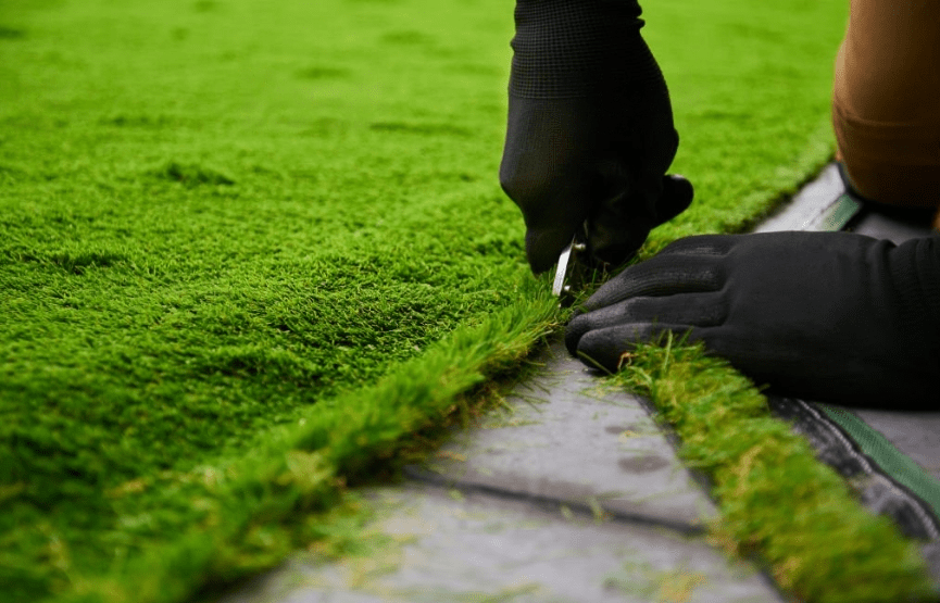 A man cutting the Artificial grass carpet