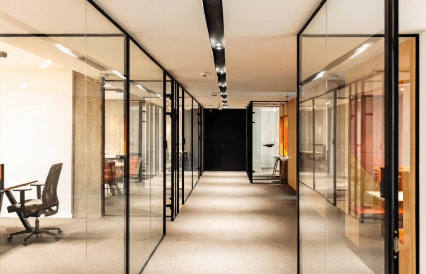 a hallway with glass walls and a black door
