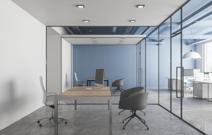 a office with glass partition having a desk and chairs